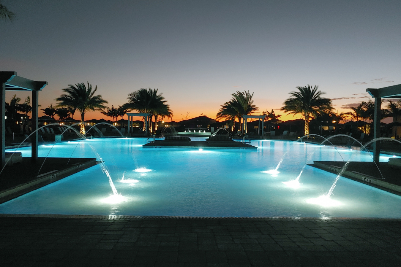 Sunset behind resort-style pool in Verdana Village, a gated community in Estero.