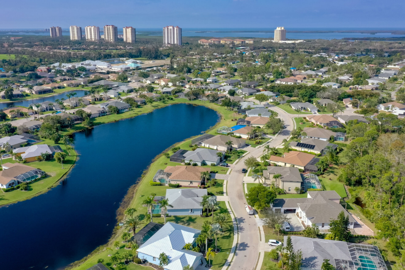 Aerial view of Estero Florida with large lake, housing, and high-rises in the distance