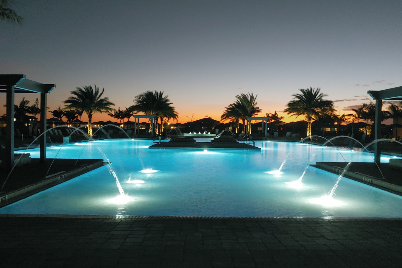 Luxury resort swimming pool with island beds and palm trees at Verdana Village in Estero, Fl